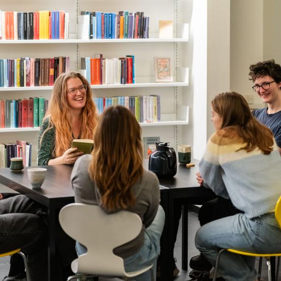 Unge der sidder omkring et bord