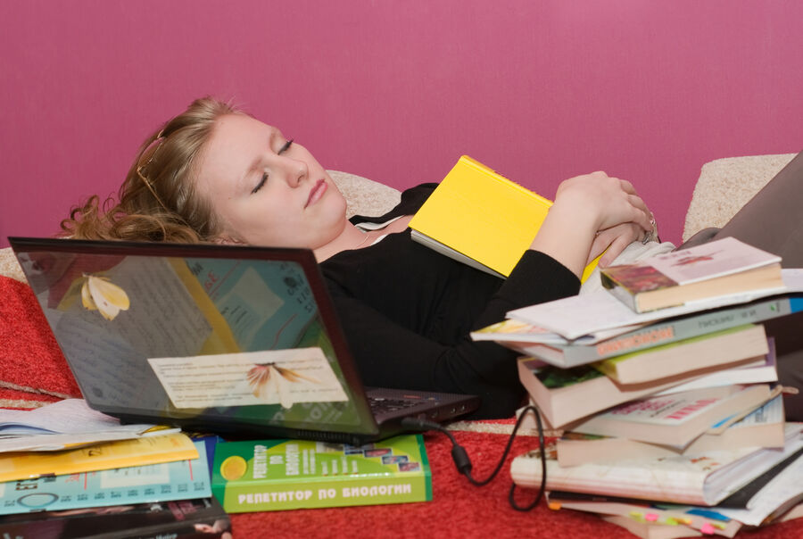 En person, der sover på og med bøger