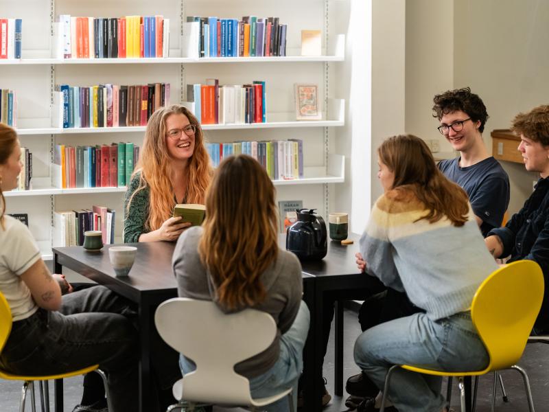 Unge der sidder omkring et bord