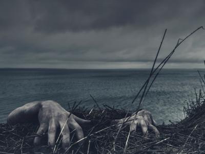 Mørk strand med zombie-hænder