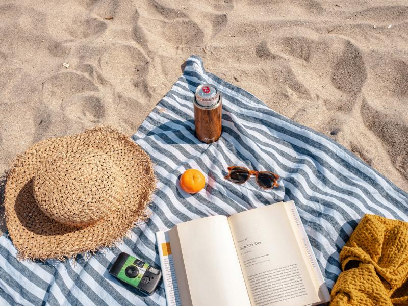 Tæppe og bog på strand